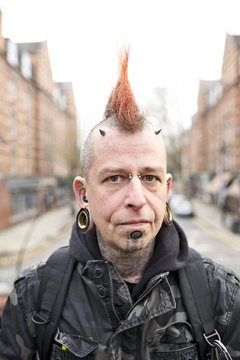 Portrait of tattooed man wearing ear plugs