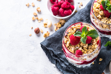 Fototapeta na wymiar Yogurt parfafait with granola and raspberries in glass.