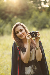 Young woman with camera outdoors.