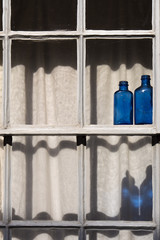 Blue glass bottles in the window Little Walsingham Norfolk England