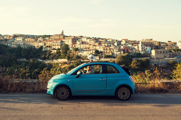 The girl looking at Ragusa skyline from the car, Italy. - obrazy, fototapety, plakaty