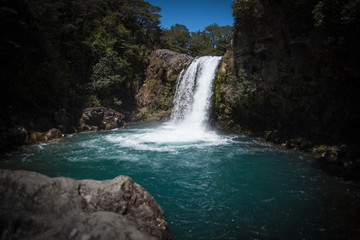 Fototapeta na wymiar A waterfall flowing into a pool of water in New Zealand. 