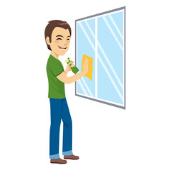 Young happy man cleaning window with yellow rag cloth and green cleaning spray