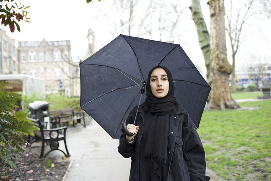 Portrait of a young Muslim woman with an umbrella