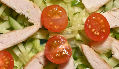 Salad from vegetables, cherry tomatoes, cucumbers, lettuce and turkey meat