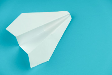 White handmade paper plane on blue background