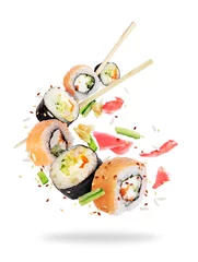 Keuken foto achterwand Sushi bar Verschillende verse sushi rolt met stokjes bevroren in de lucht op witte achtergrond