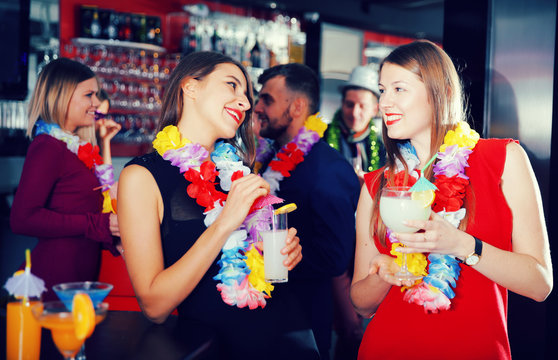 Female colleagues on company party in Hawaiian style in bar