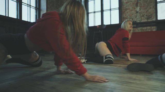 Three beautiful girls are dancing twerk in a hall. Booty shake.