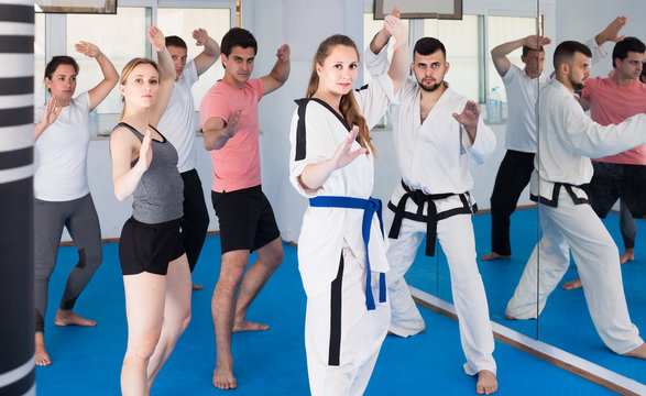  adults attempting to master new moves during karate class
