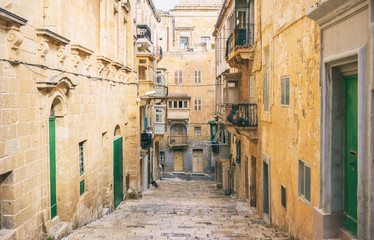 Fototapeta na wymiar Malta, Valletta. Traditional narrow street with stairs in the city center