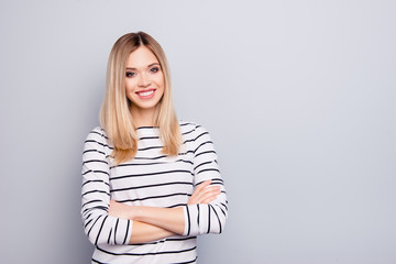 Portrait with copy space, empty place for advertisement of trendy, attractive, charming, nice woman having her arms crossed looking at camera isolated on grey background