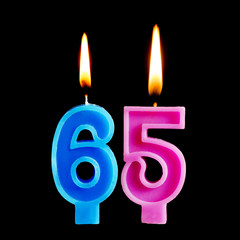 Burning birthday candles in the form of 65 sixty ive figures for cake isolated on black background. The concept of celebrating a birthday, anniversary, important date, holiday