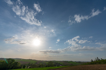 Fototapeta na wymiar Abendsonne mit Wolken in Hügellandschaft