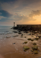 Dawn sky over wooden groyne  at harbour mouth. Seaton sluice, Northumberland, England, UK.