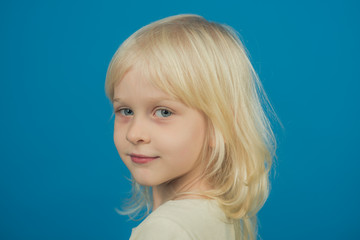 Fashion style and beauty look. fashion hairstyle of cute little blond girl on blue background.