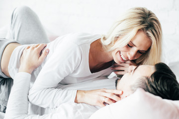 Young couple relaxing, embrace and have fun lying on the bed. .