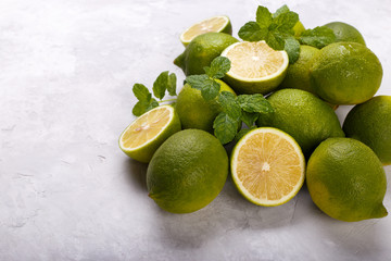 Ripe limes and mint on stone background. flat lay