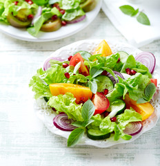 Red and yellow fresh tomato salad with  pomegranate seeds