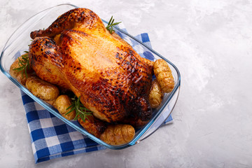 Roasted chicken and potatoes on gray stone background, flat lay with copy space. Menu or recipe template