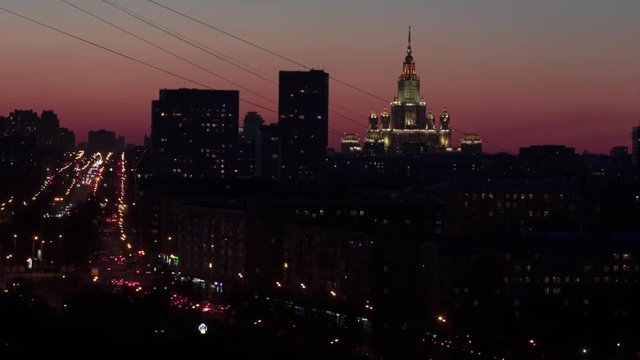 Moscow cityscape at sunset. Timelapse. MSU (Lomonosov Moscow State Univercity) and road traffic.