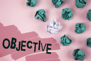 Handwriting text Objective. Concept meaning Goal planned to be achieved Desired target Company mission written on Painted Pink background Crumpled Paper Balls next to it.