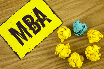 Fototapeta premium Handwriting text Mba. Concept meaning Master of Business Administration Advance Degree After College Studies written on Sticky Note paper on wooden background Crumpled Paper Balls next to it.