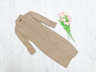 Khaki dress and a bouquet of tulips. Fashionable concept