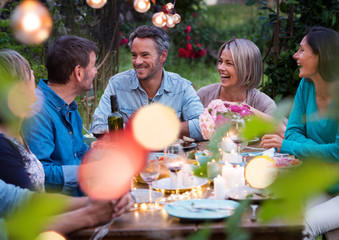 Beautiful summer evening in the garden, a group of friends in their forties have a good time...