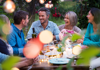 Beautiful summer evening in the garden, a group of friends in their forties have a good time...