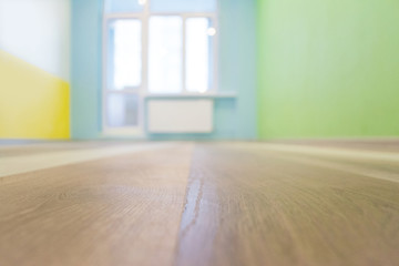 Empty kids room interior background with color walls and wooden flooring, shallow depth of focus