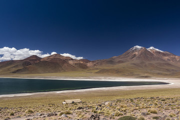 miniques volcano and mountains with snow and miscanti lagoon at andes mountain range