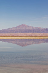 mountain reflected in salt flats lake in atacama desert
