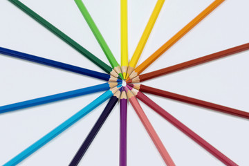 Color pencils isolated on white arranged in circle.