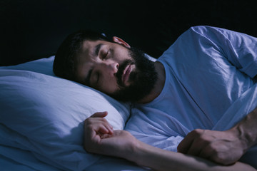 Portrait of a man sleeping in the bed at home