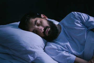 Portrait of a man sleeping in the bed at home