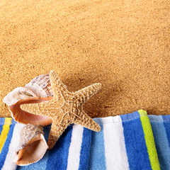 Beach background sand border towel starfish seashell summer vacation holiday seashore scene square format photo