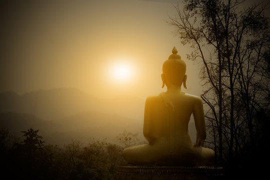 Buddha Statue on the mountain with sunset background