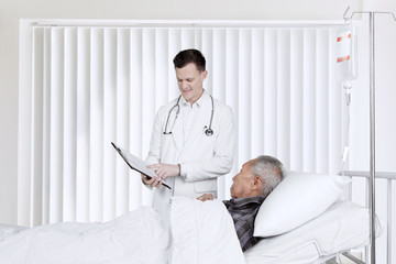 Doctor and patient with clipboard in recovery room
