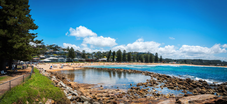 People enjoying a beautiful sunny day at Avoca Beach on the Central Coast, New South Wales, Australia.