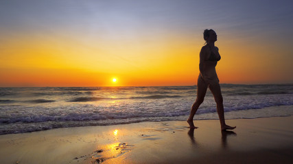 Fototapeta na wymiar Girls run out of ocean water at sunset on tropical beach
