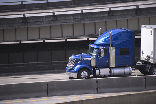 Blue Star Big Rig Semi Truck With Semi Trailer Running On Urban City Road With Overpass Intersection