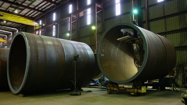 Two wind tower sections being made in factory.