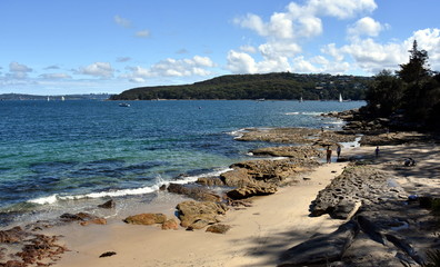 Fototapeta na wymiar Delwood beach on a sunny day in summer. Dobroyd Head in the background. View from Fairlight Walk, Esplanade Park, which is part of the Manly to Spit Bridge Walkway.