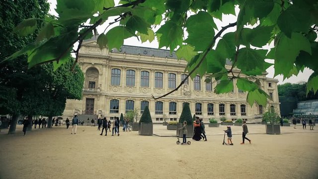 Cinematic steadicam shot of Paris, Jardin des Plantes, natural history museum and visitors at cloudy spring day
