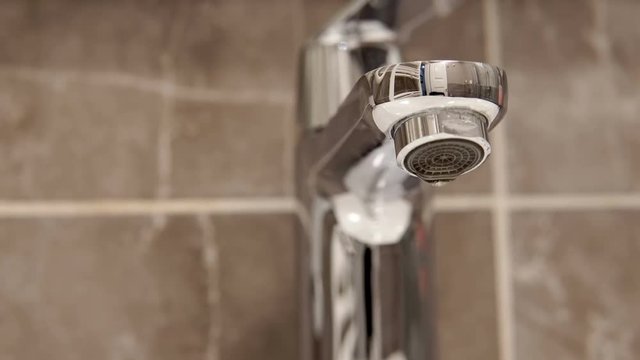 Metal tap and water drop dripping  loop background close up  cinematic dof
