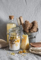 Bath accessories - homemade sea salt with calendula, natural shampoo, brush, washcloth, pumice, homemade oat soap. Health, beauty concept. Flat lay