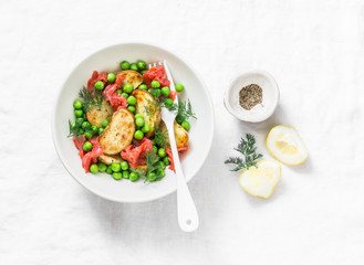 Young baked potato, smoked salmon, green peas and dill salad on light background, top view