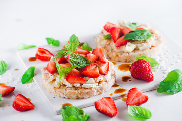 Healthy snack with crisp bread, fresh strawberries, soft creme cheese, mint, balsamic vinegar. Easy breakfast close-up on a white background with copy space.