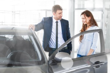 Happy couple with car dealer